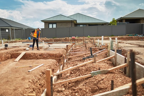 Tradesmen working on construction site next to neighbouring properties