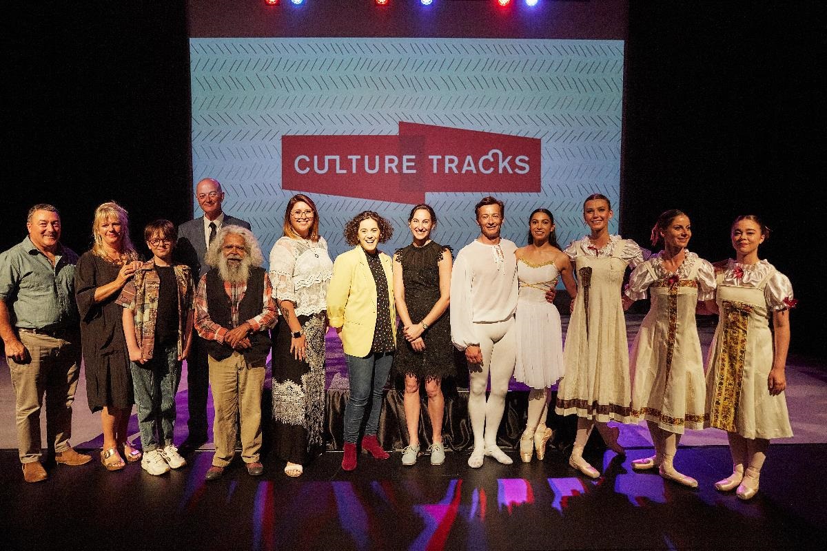 Performers at the Culture Tracks Launch, standing on stage at The Memo with the Culture Tracks logo projected behind them.