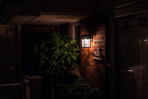 A house front verandah at night with a light on.