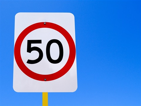 A 50 kilometre per hour speed limit sign on a blue sky background.