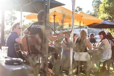 Musicians performing in an outdoor dining space.