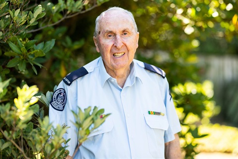 Barry Marshall, wearing his CFA uniform, in front of a green tree.