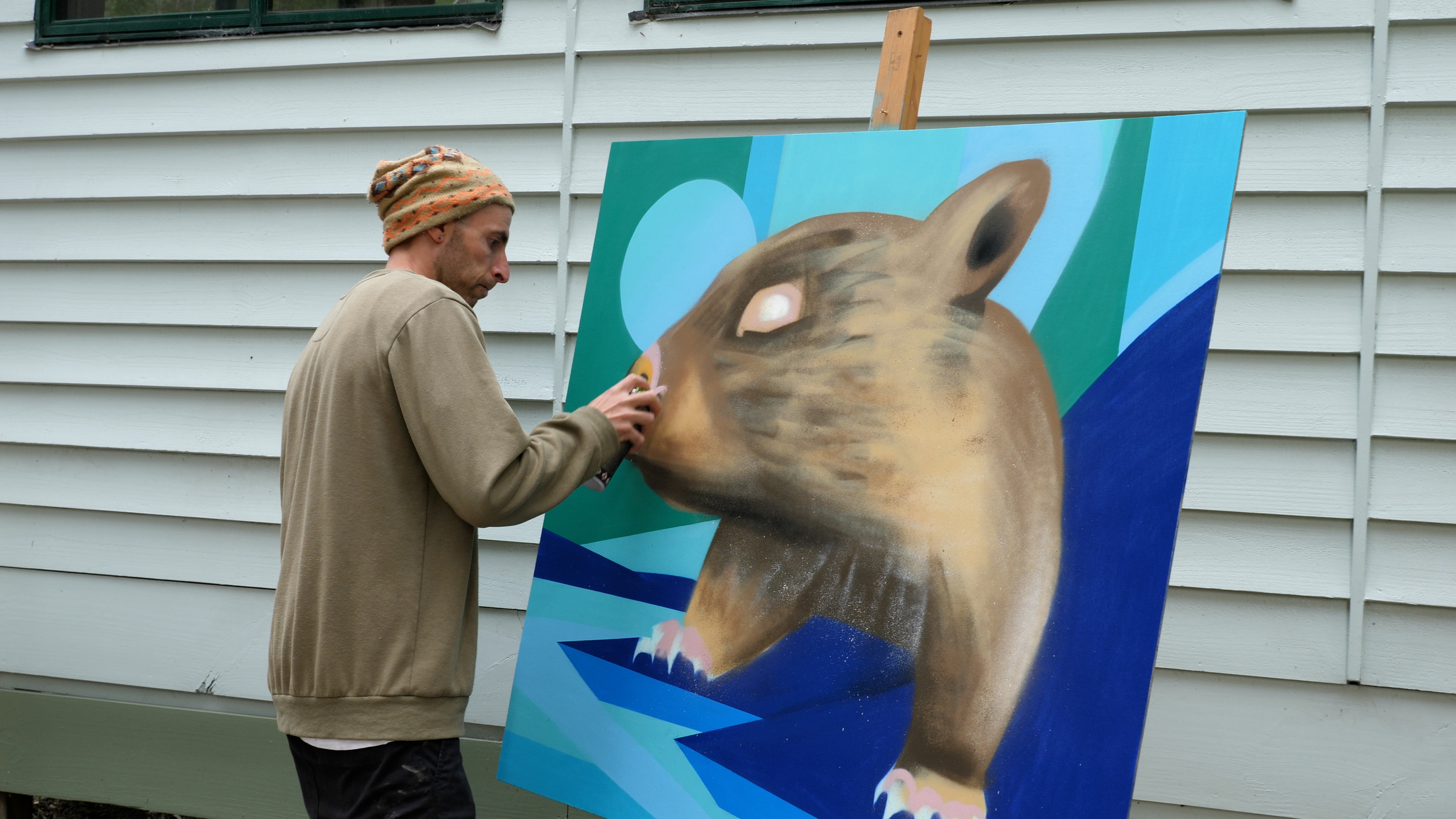 A person painting a picture of a wombat.