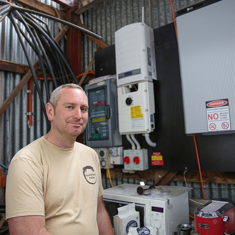 Ramarro Farm owner Oliver in front of sustainable battery funded through EUA process.jpg