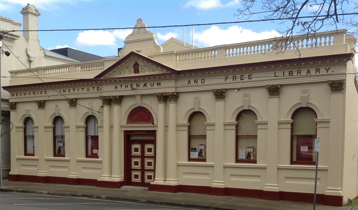 A historic building with a cream-colored facade and red accents, labeled 