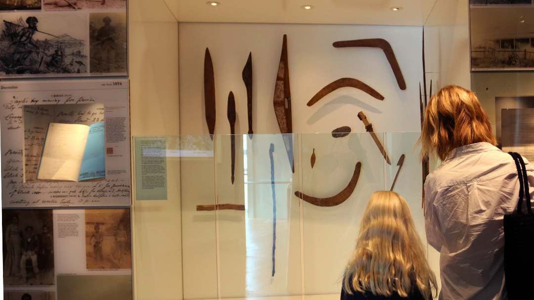 A mother and young child observing traditional Aboriginal artefacts