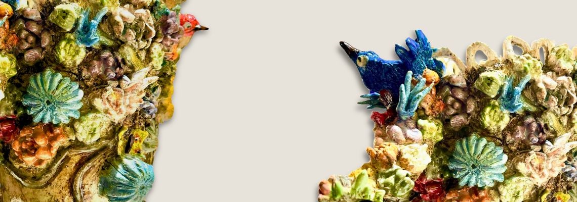 Colourful-ceramic-sculpture-featuring-coral-like-textures-shells-and-a-bright-blue-bird-emerging-from-an-organic-reef-inspired-form-on-a-light-background.jpg