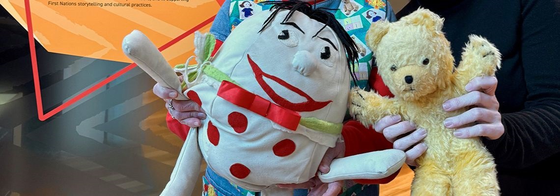 One pair of hands holding Humpty and other pair of hands holding Little Ted (from Play School)