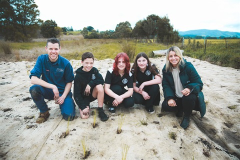 a group of people sitting in the sand